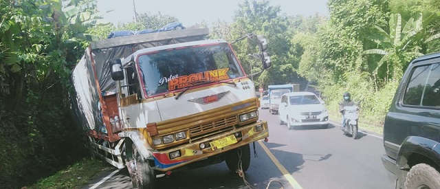 Kecelakaan Truk Muat Kayu 18 Ton Tak Kuat Nanjak, Mundur dan Terperosok ke Got