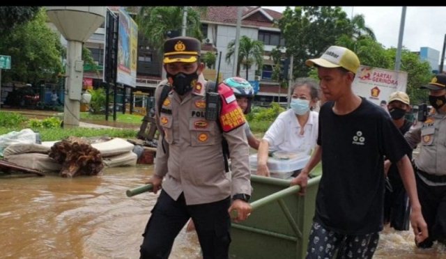 Kapolsek Kembangan Mengangkut Seorang Nenek Lintasi Banjir