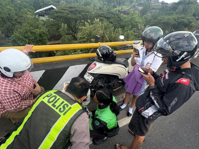 Petugas kepolisian mengevakuasi remaja yang mencoba bunuh diri di jembatan short cut Penyalin-Samsam Tabanan.