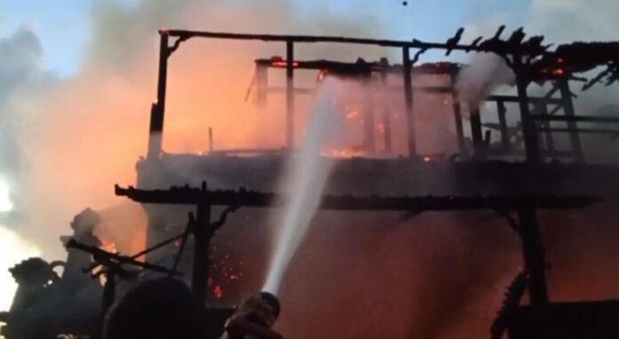 Petugas pemadam kebakaran memadamkan rumah Joglo yang terbakar di Banjar Yeh Gangga