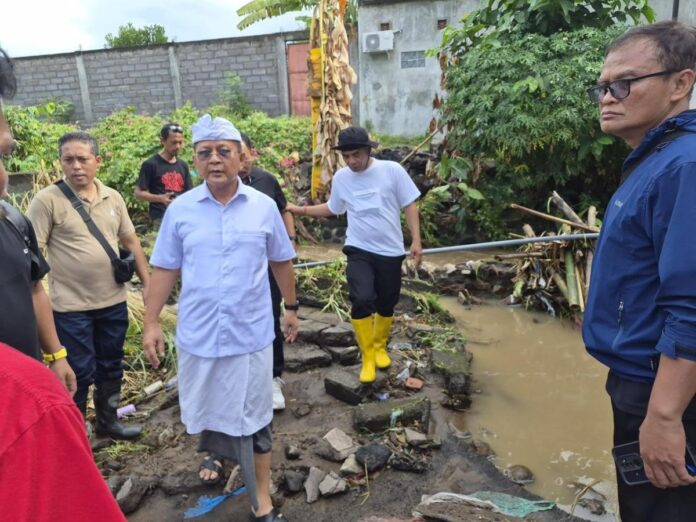 Bupati Buleleng I Nyoman Sutjidra meninjau lokasi rumah warga yang roboh akibat banjir di Desa Baktiseraga