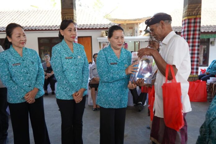 Sekretaris I TP PKK Provinsi Bali Ny. Seniasih Giri Prasta menyerahkan bantuan sosial kepada masyarakat saat Aksi Bergerak dan Berbagi di Kabupaten Gianyar Tahun 2026