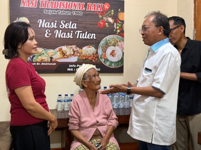 Gubernur Bali Wayan Koster menyapa masyarakat saat meninjau program berbagi makanan gratis di Warung Nasi Pindang Dadong Rintin, Gianyar, dalam rangka peringatan Tumpek Krulut 2026.