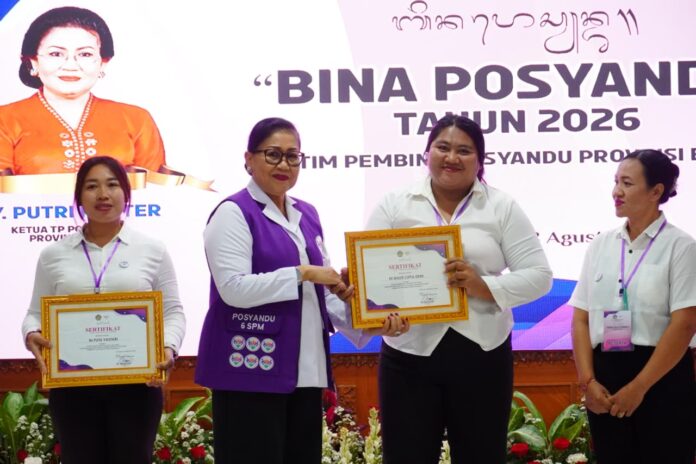 Ny. Putri Suastini Koster menyerahkan penghargaan kepada peserta Bimtek Bina Posyandu Angkatan XI 2026