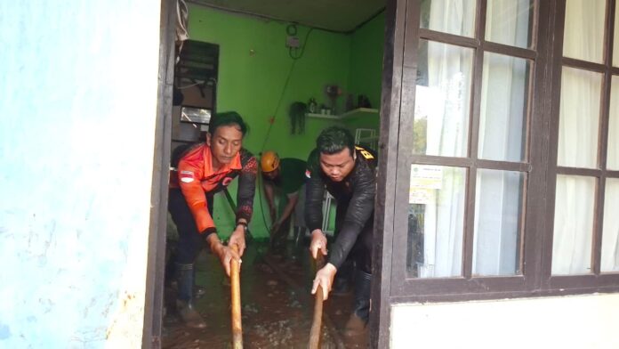 Petugas BPBD Tabanan dan tim gabungan membersihkan material tanah longsor di rumah warga Kecamatan Kediri.