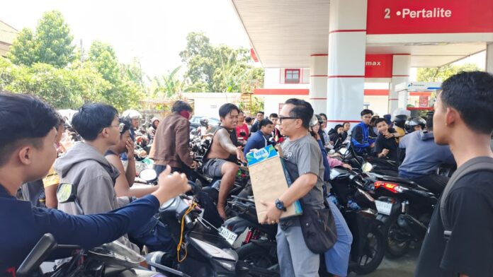 Bupati Buleleng Nyoman Sutjidra dan ASN membagikan air mineral gratis kepada warga yang mengantre BBM di SPBU Singaraja.
