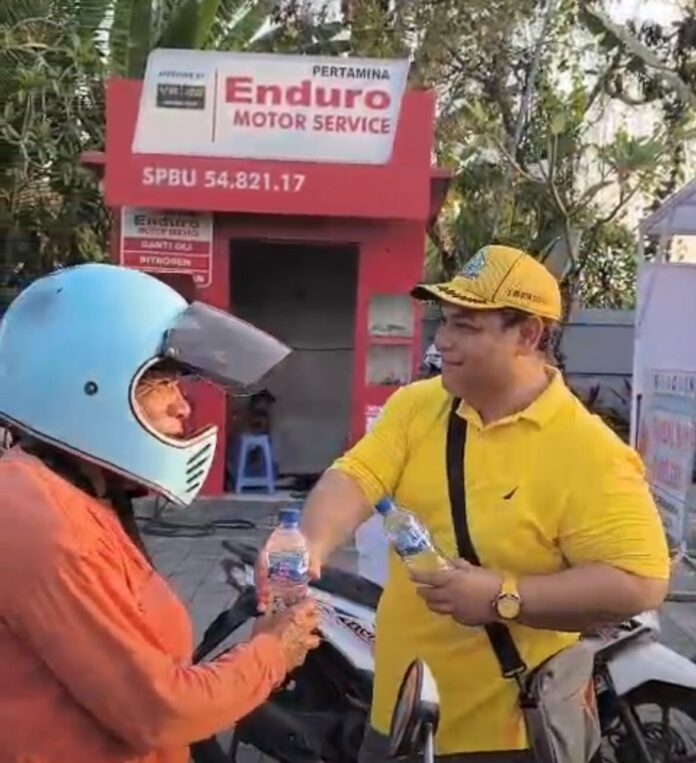 I Made Asta Dharma, Wakil Ketua DPRD Tabanan dari Partai Golkar, membagikan air mineral kepada pengendara yang mengantre BBM di SPBU Gerokgak.