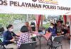 Personel Polres Tabanan melayani warga di tenda Pos Pelayanan dekat SPBU Sanggulan saat antrean BBM memanjang hingga sekitar satu kilometer untuk sepeda motor.